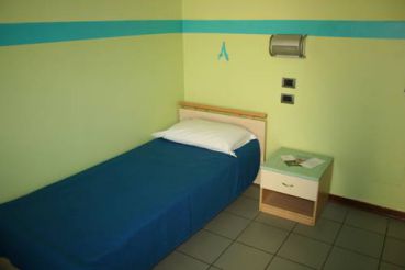 Односпальная кровать в общей спальне для мужчин с общей ванной комнатой 

